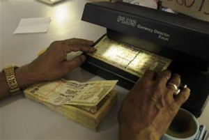 A cashier checks Indian currency notes inside a bank in Agartala